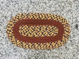 Handtufted Doormat With An Oval Shape And A Braided Design.